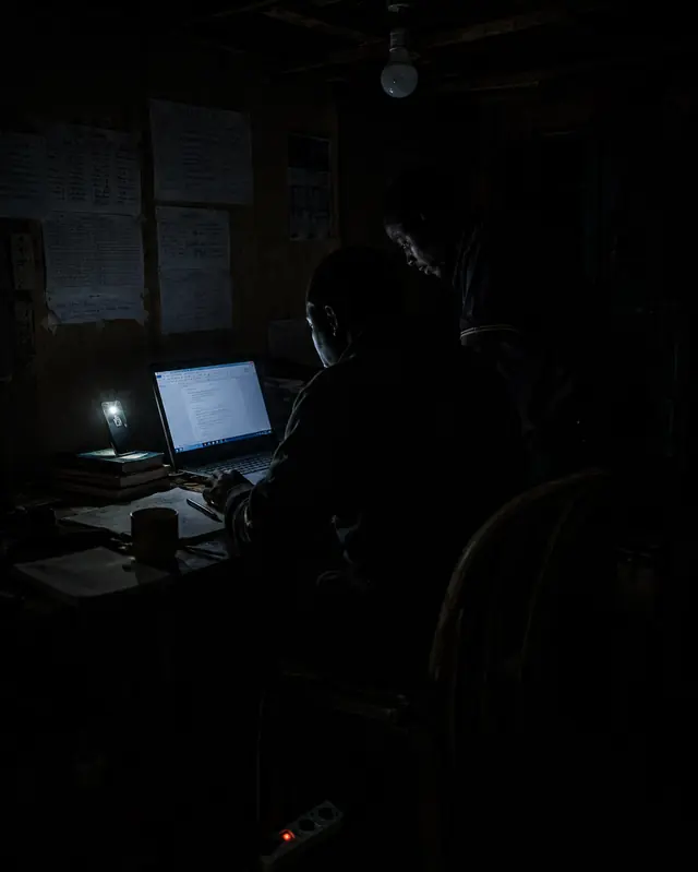 Two at one laptop in the dark